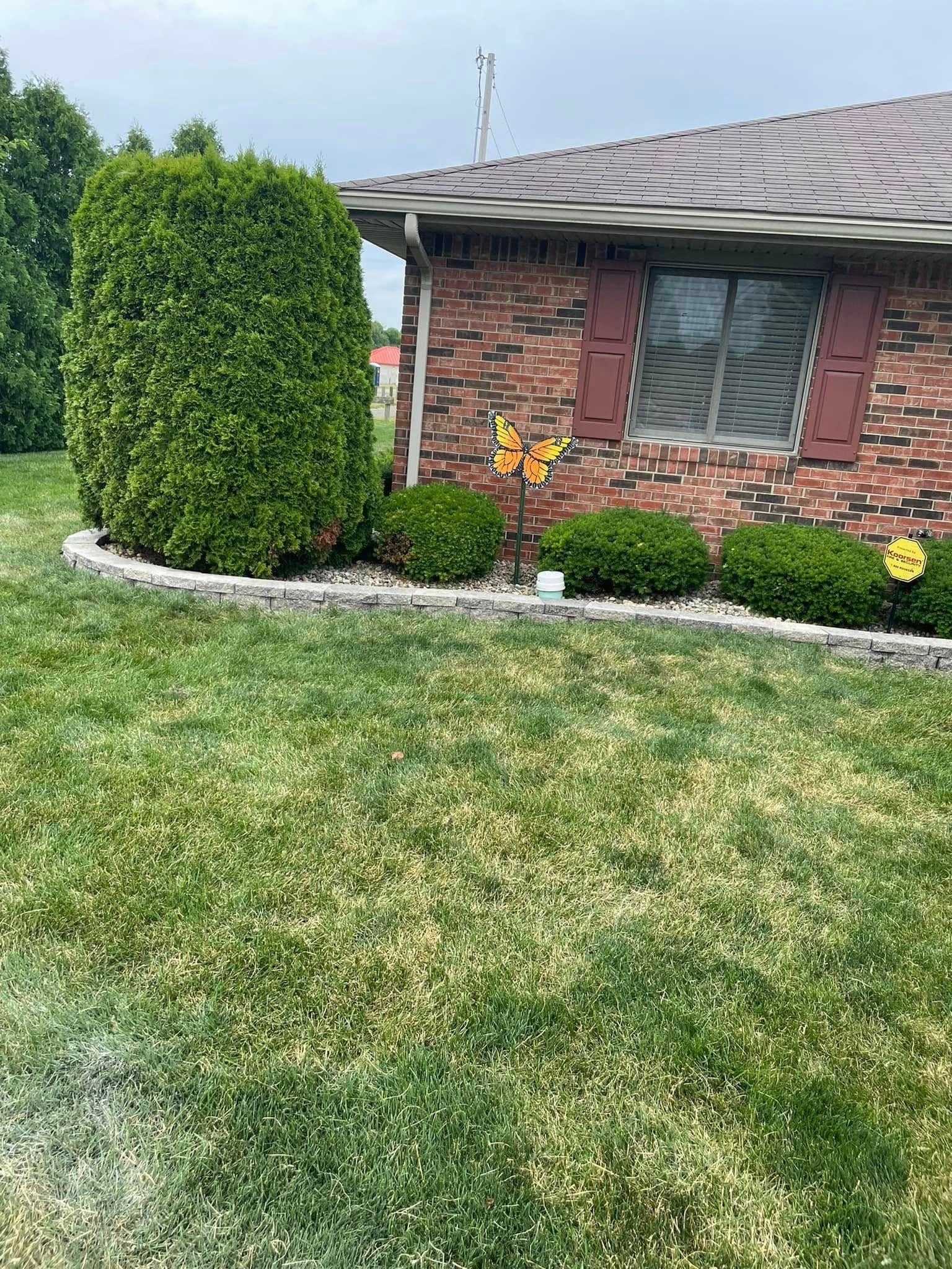 A brick house with a lush green lawn in front of it.