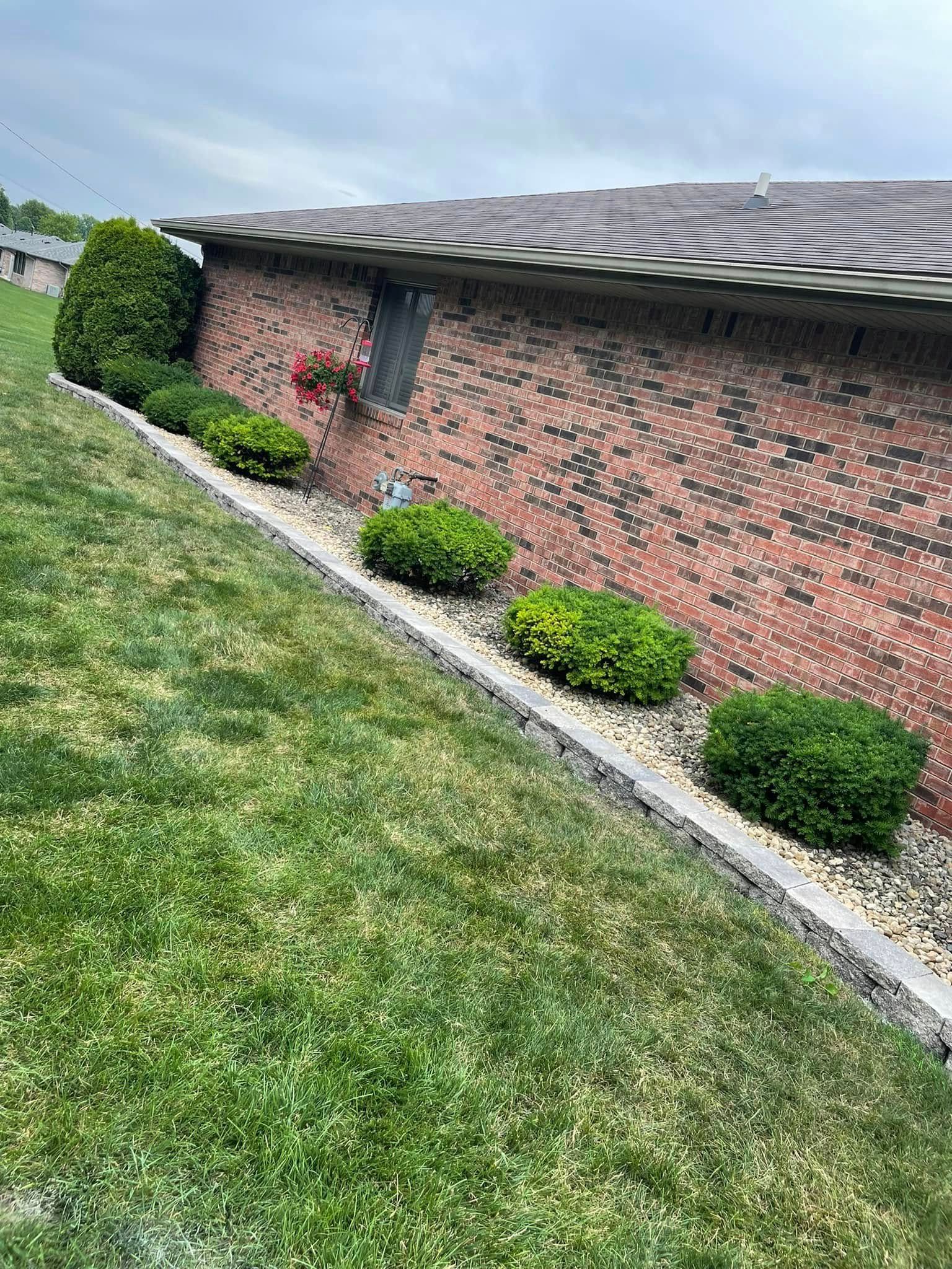 A brick house with a lush green lawn in front of it.