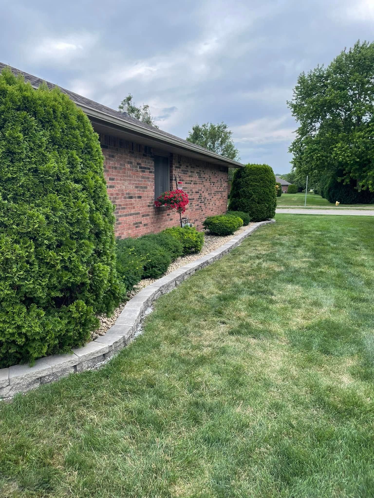 A brick house with a lush green lawn in front of it.