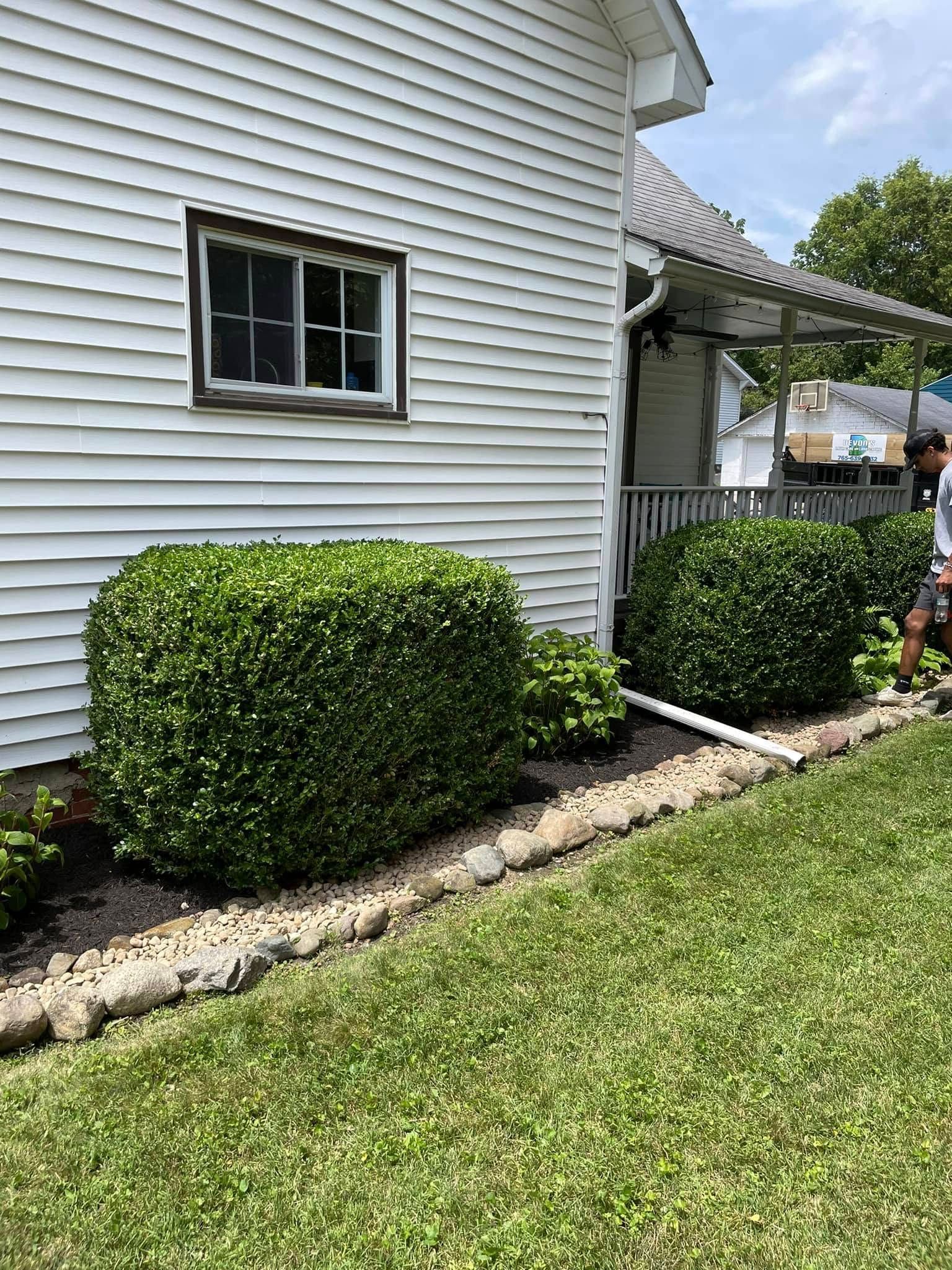 A man is standing in front of a white house.