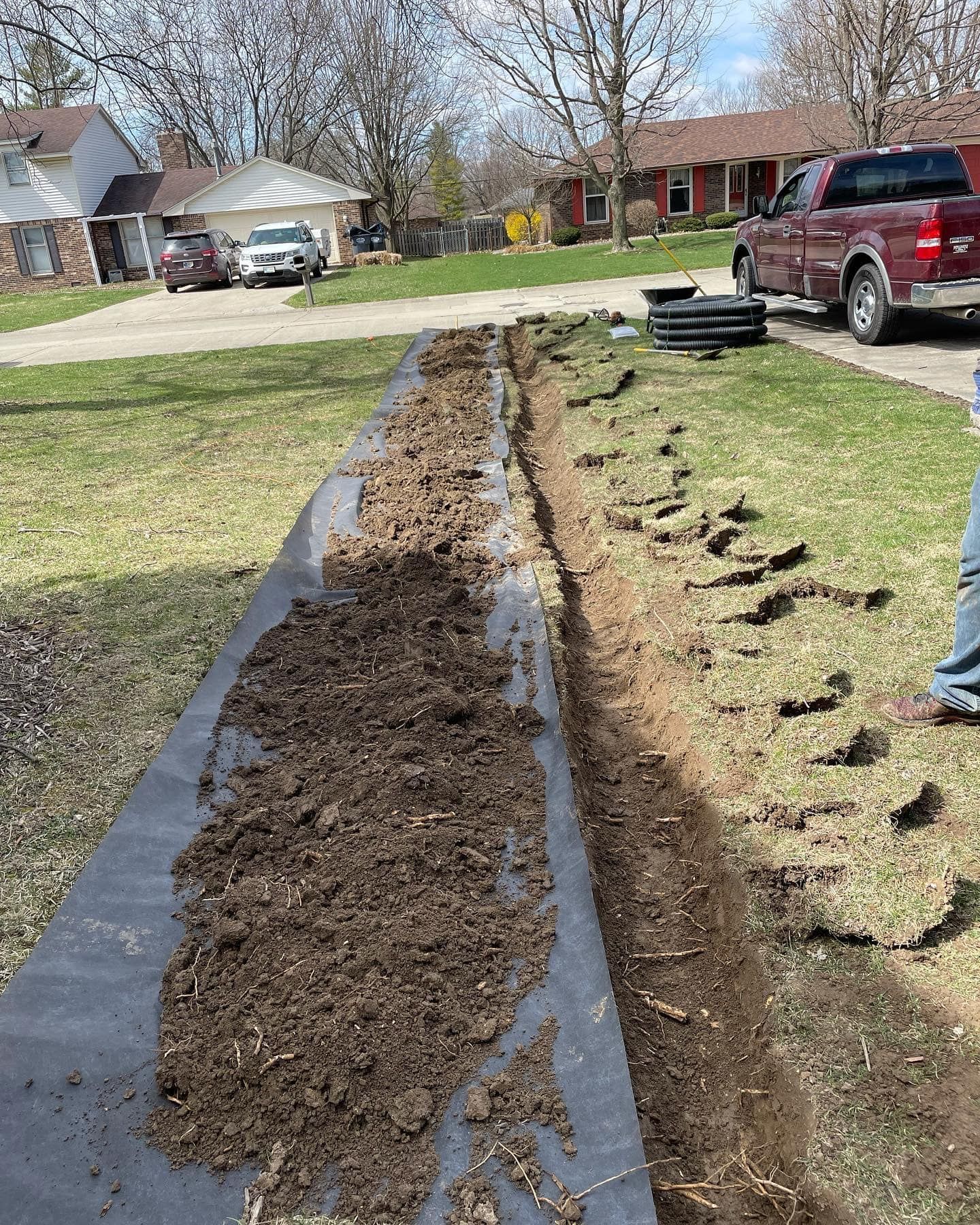 A red truck is parked in the driveway of a house.