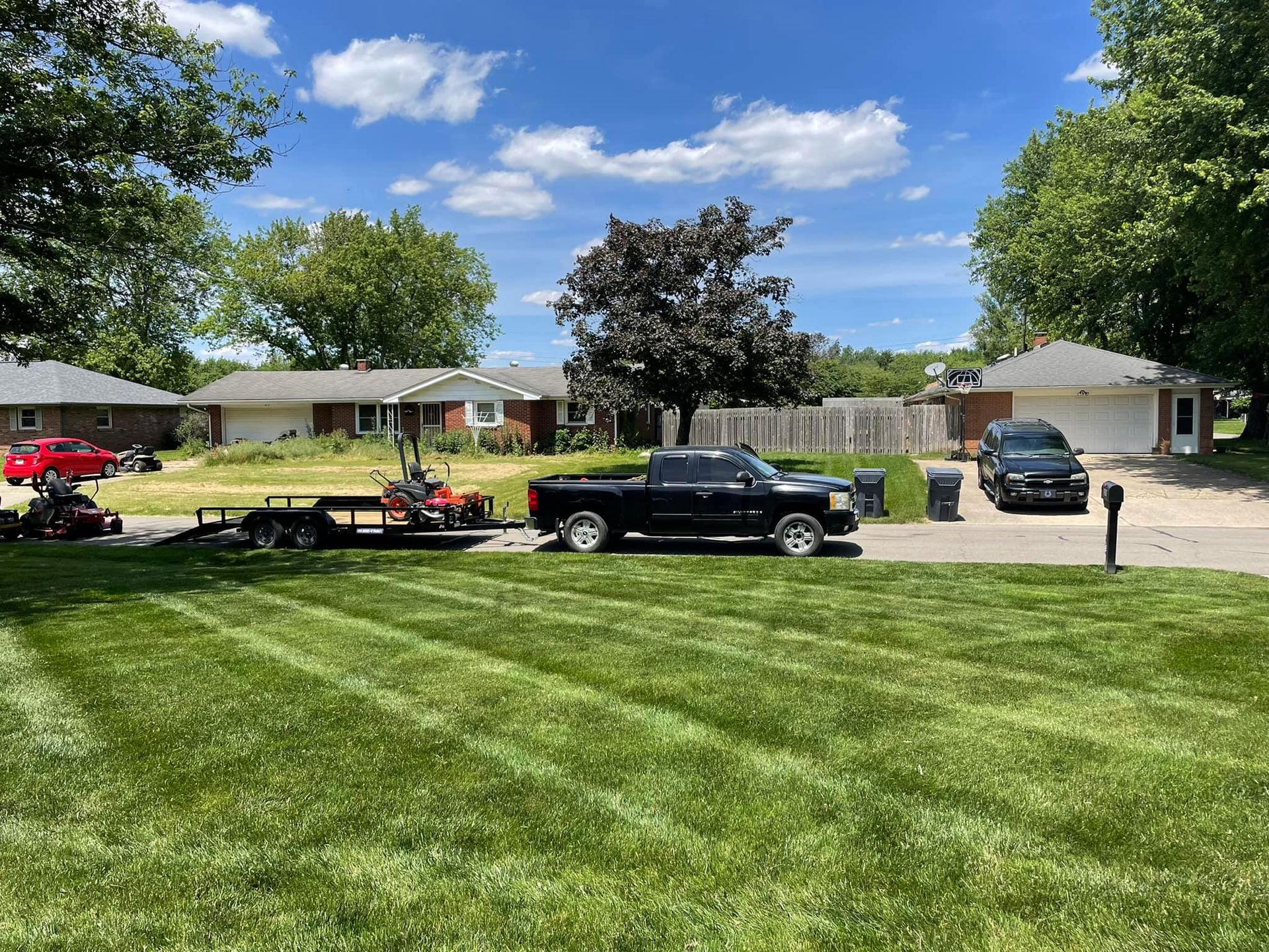 A black truck is parked in front of a lush green lawn.