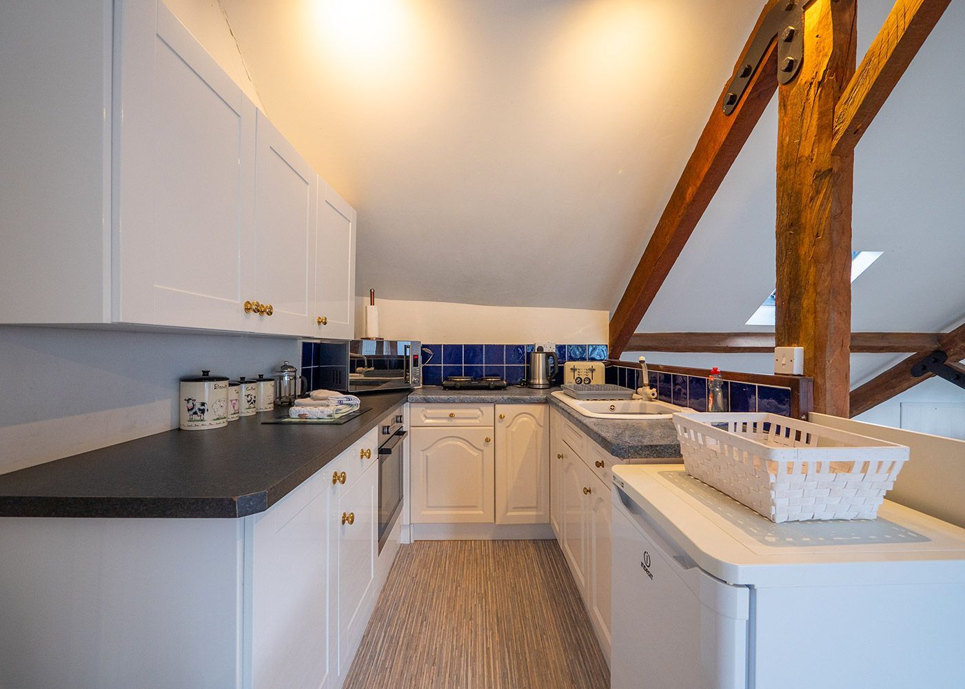 A kitchen with white cabinets , a sink , a refrigerator and a dishwasher.