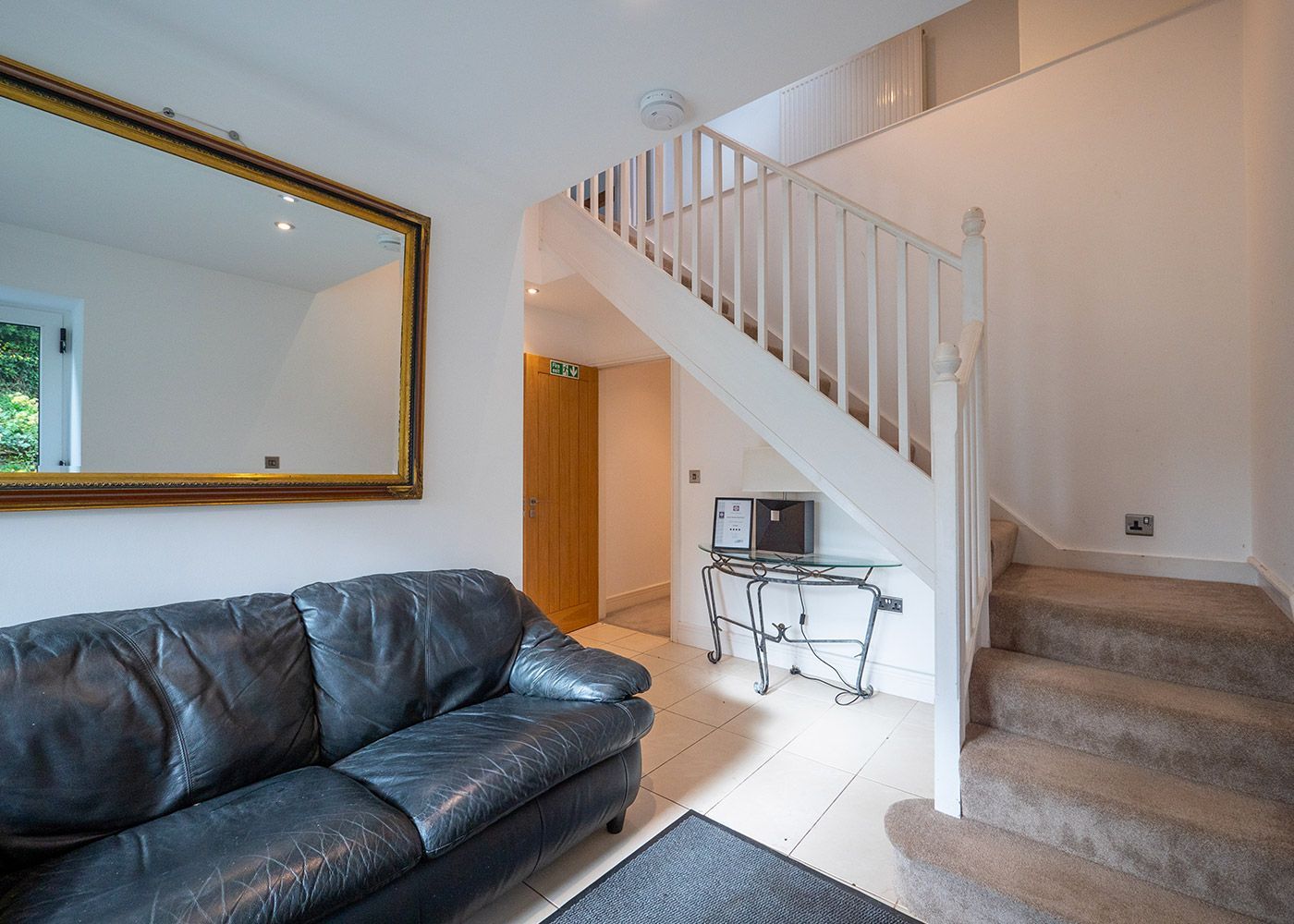 A living room with a couch and stairs leading up to the second floor.