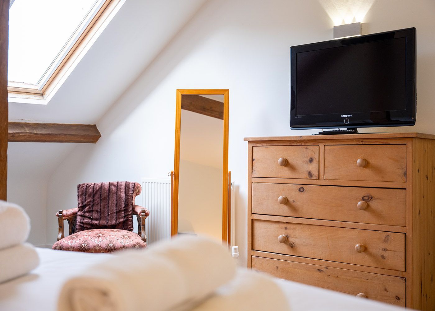 A bedroom with a dresser and a flat screen tv