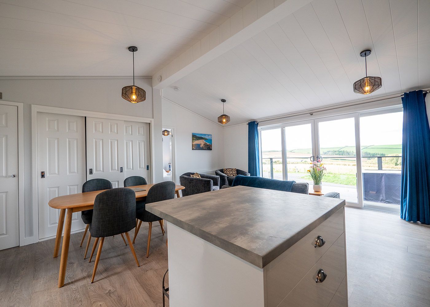 A living room with a table and chairs and a large island in the middle.