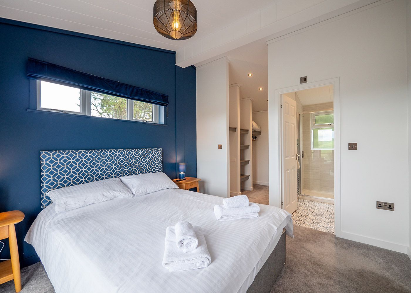 A bedroom with a king size bed and blue walls.