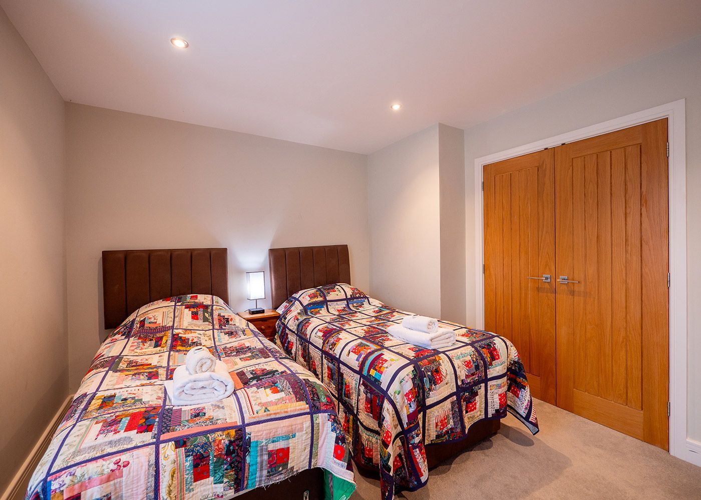 A bedroom with two twin beds and a closet.