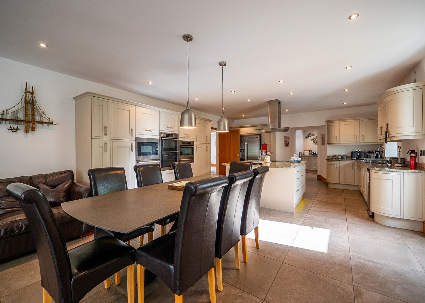 A large kitchen with a dining table and chairs in it.
