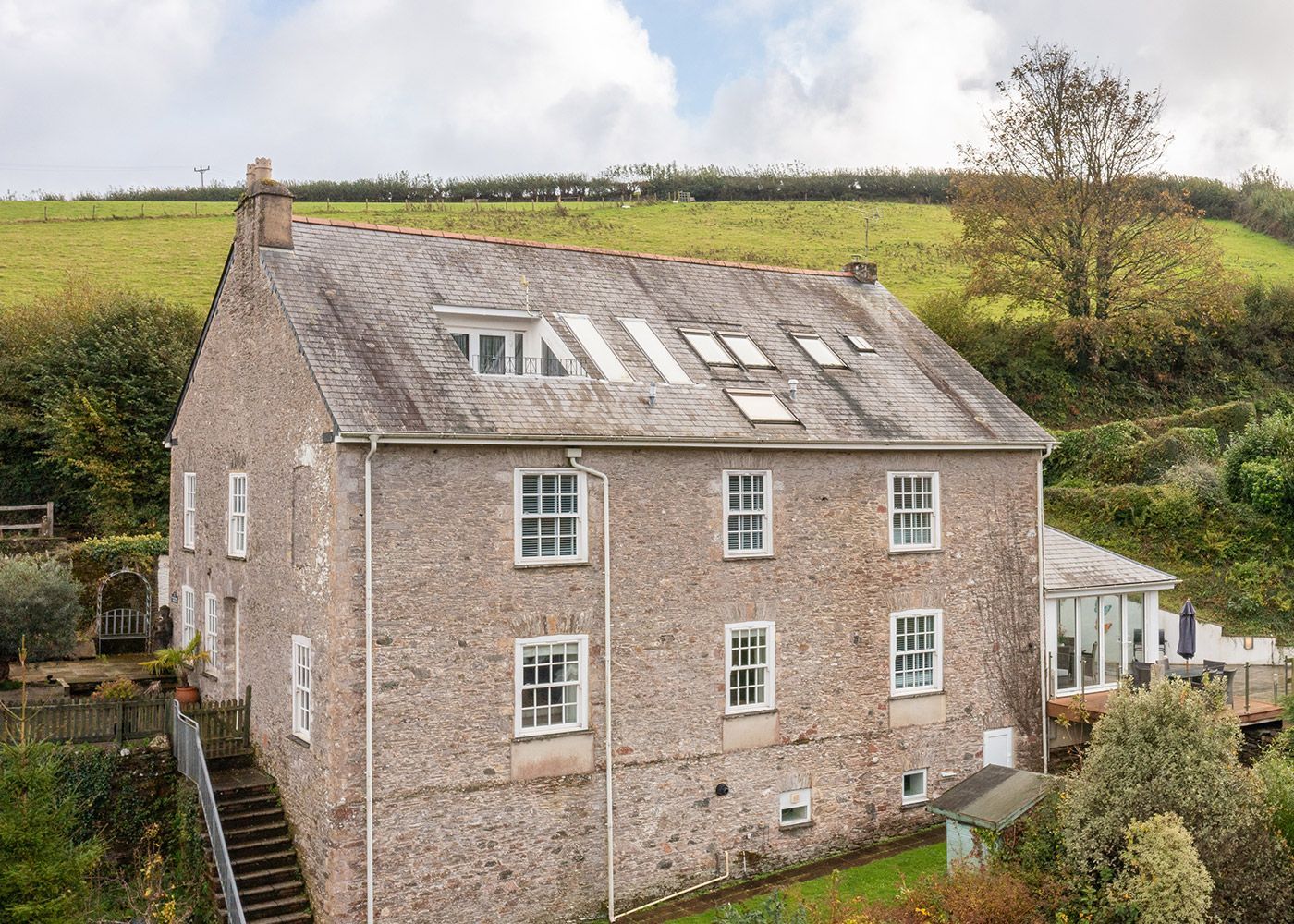 An aerial view of a large brick house in the middle of a field.