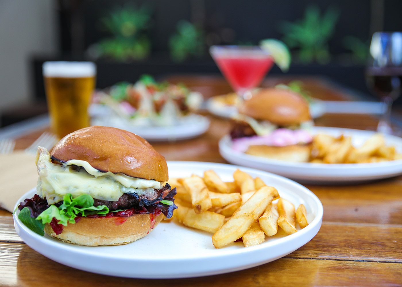 A hamburger and french fries on a plate on a table.