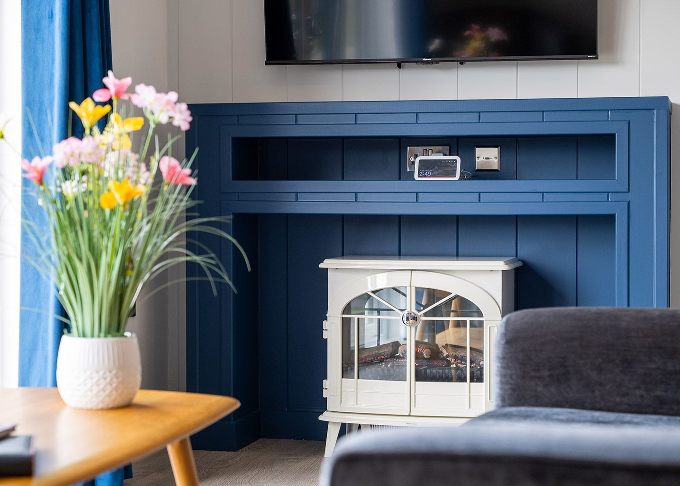 A living room with a fireplace , couch , table and television.