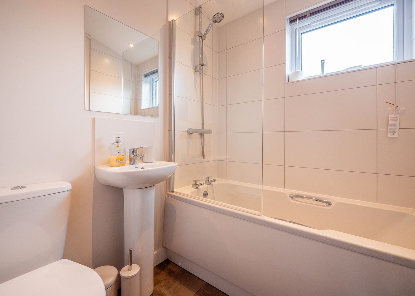 A bathroom with a toilet , sink , and bathtub.