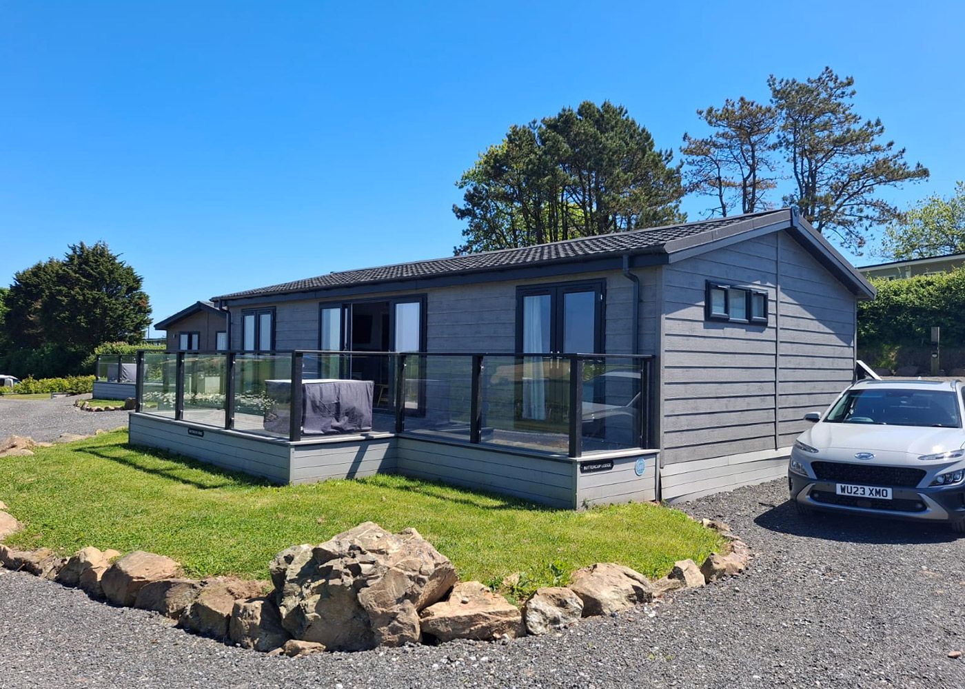 A large house with a fence around it is sitting on top of a lush green field.