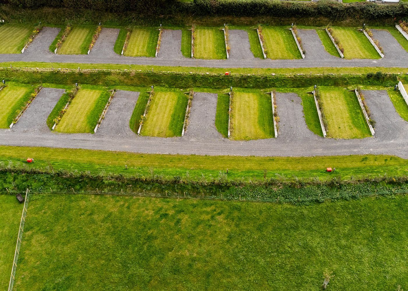 An aerial view of a park with lots of grass and parking spaces.