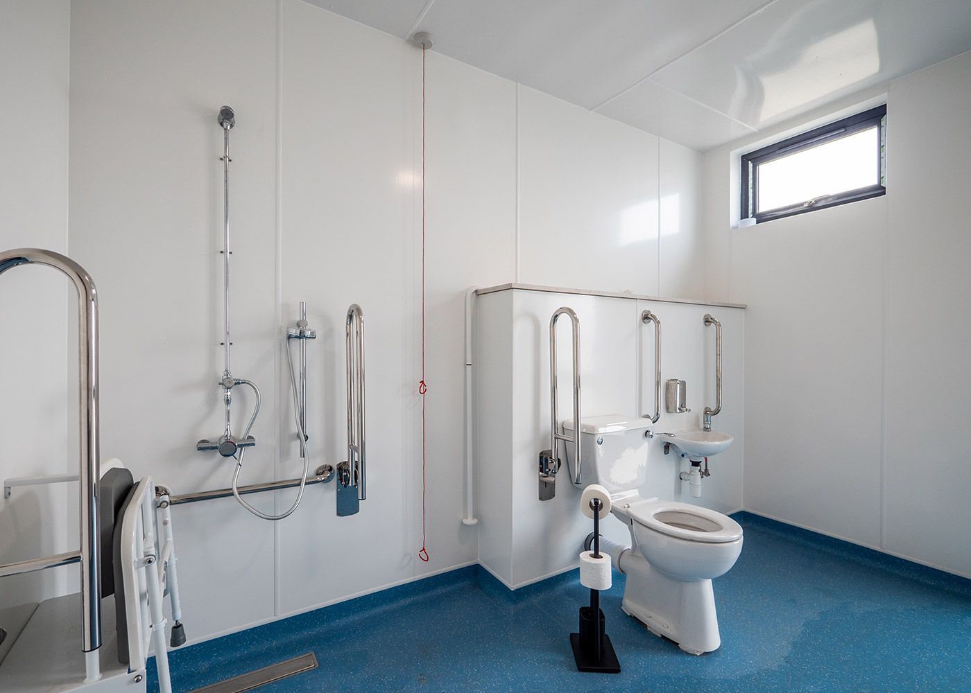 A handicapped bathroom with a toilet , sink and shower.