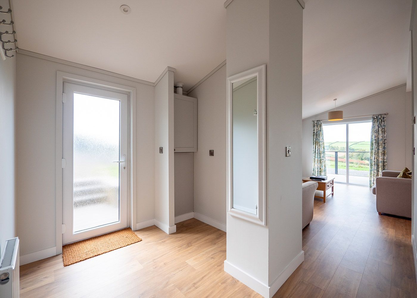 A hallway leading to a living room and a sliding glass door.