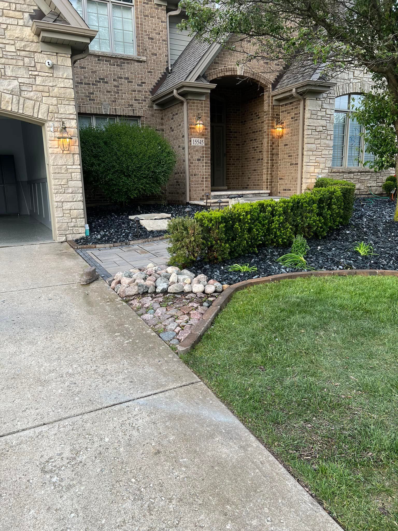 A large house with a garage and a driveway on a rainy day.