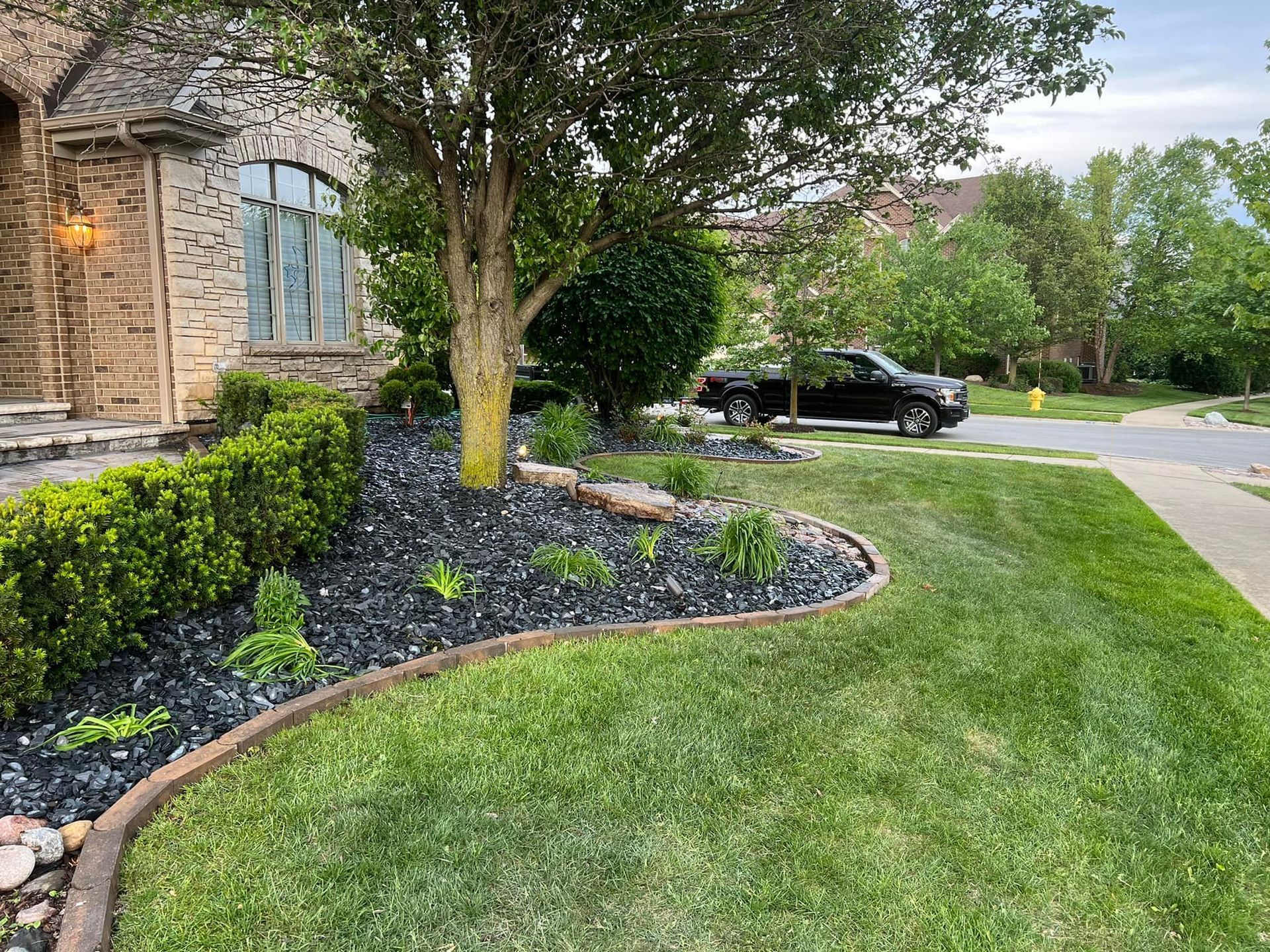 A large house with a garage and a driveway on a rainy day.