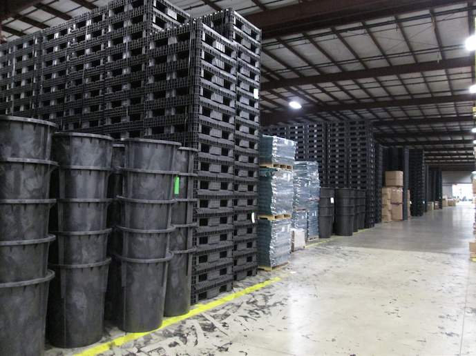 A large warehouse filled with lots of plastic pallets