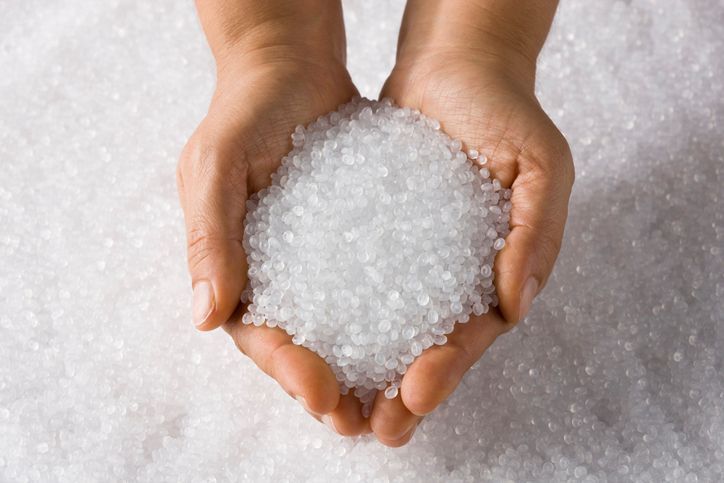 A person is holding a pile of plastic beads in their hands