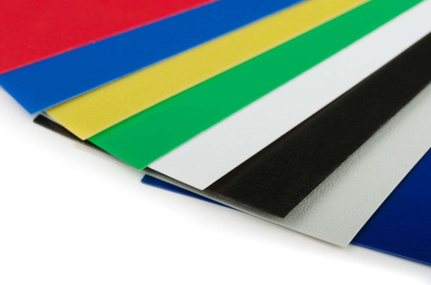 Sheets of colored paper fanned out: red, blue, yellow, green, white, black, and blue.