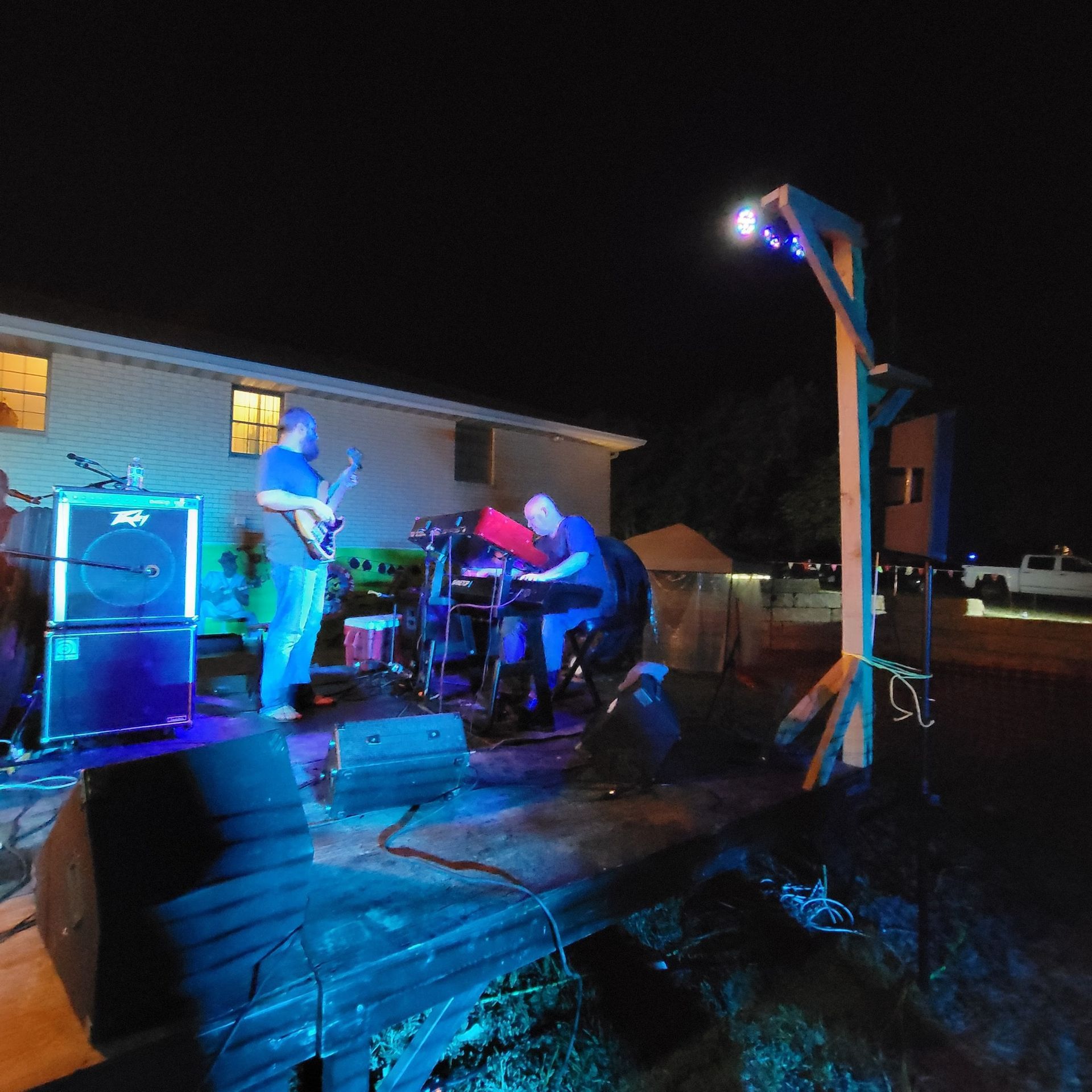 A group of men are playing instruments on a stage at night