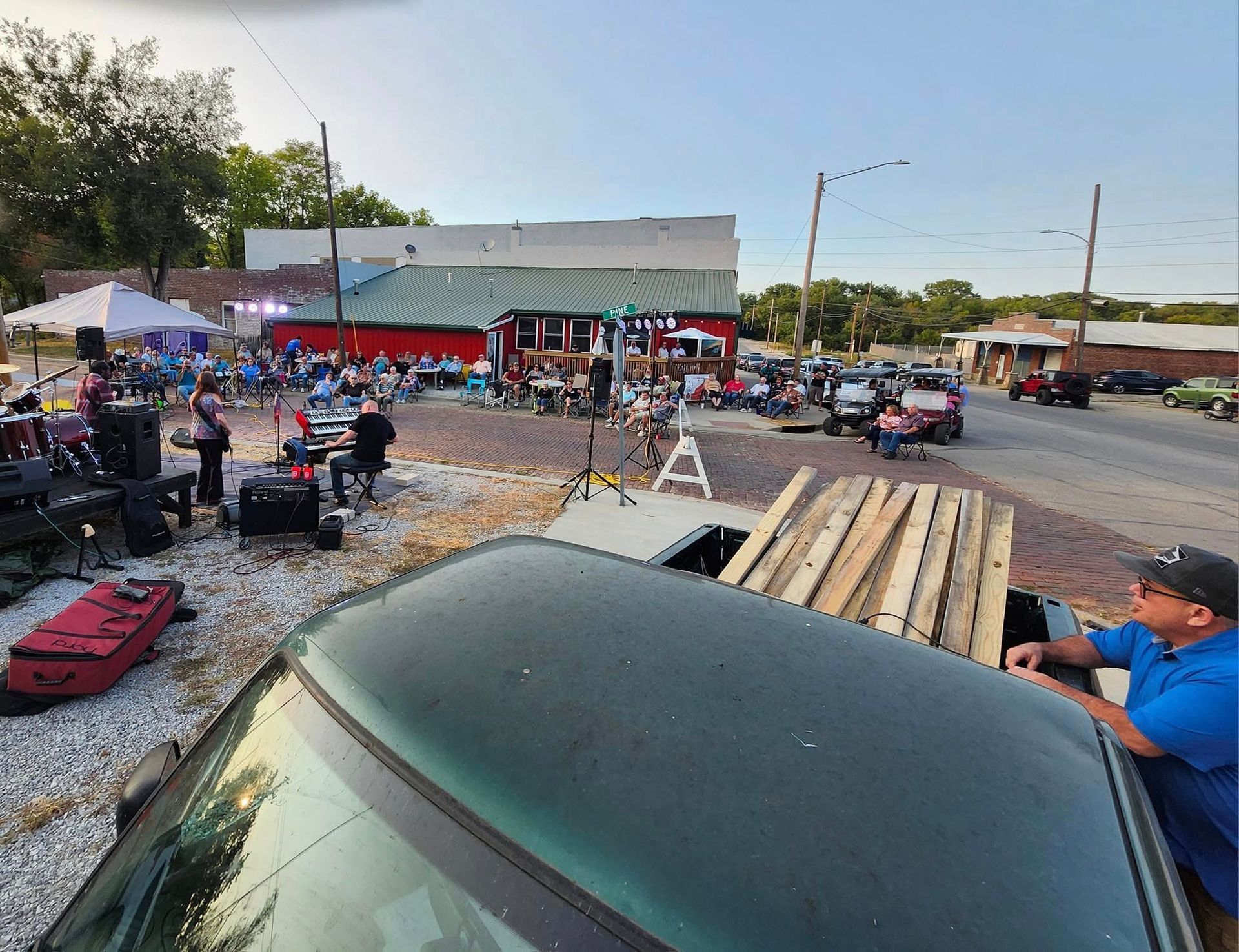 A man is standing next to a car in front of a building.