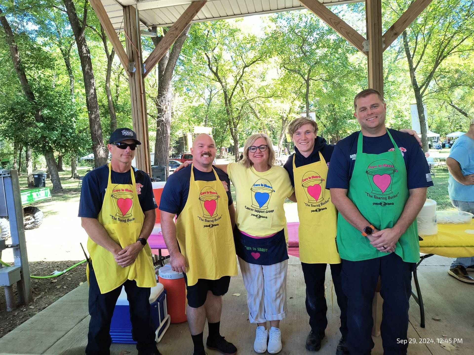A group of people wearing aprons are posing for a picture