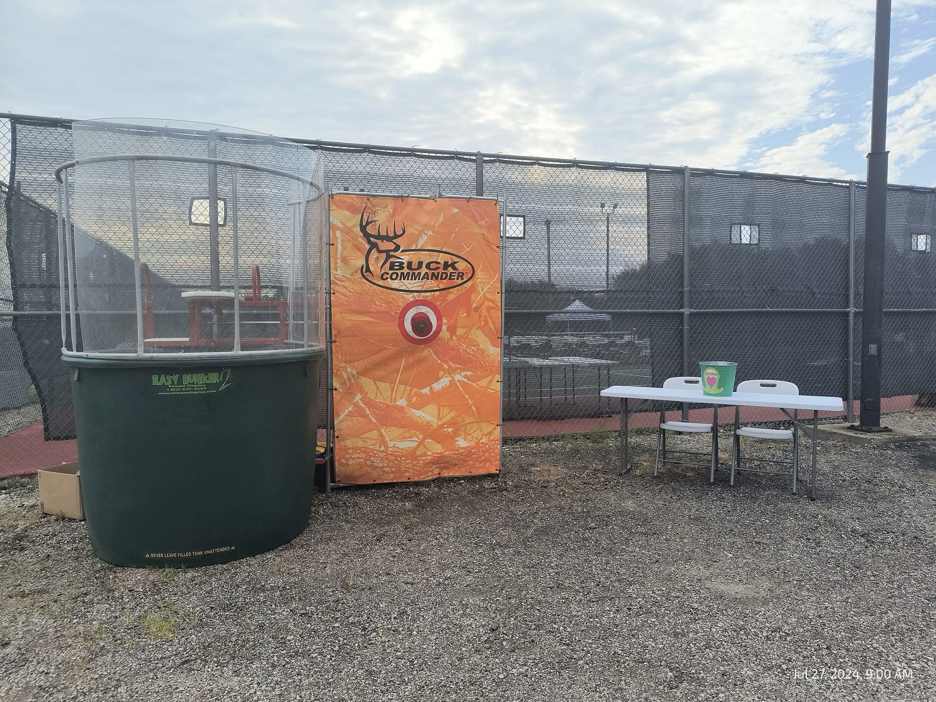 A fence with a bucket and a table in front of it.