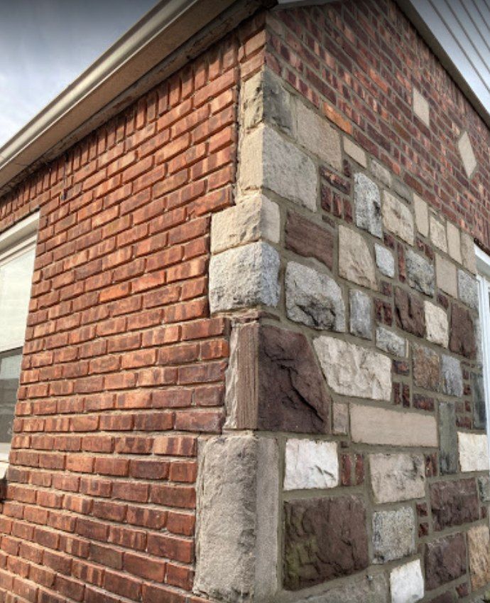 The corner of a brick and stone building with a window