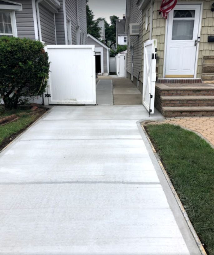 A concrete walkway leading to the front door of a house