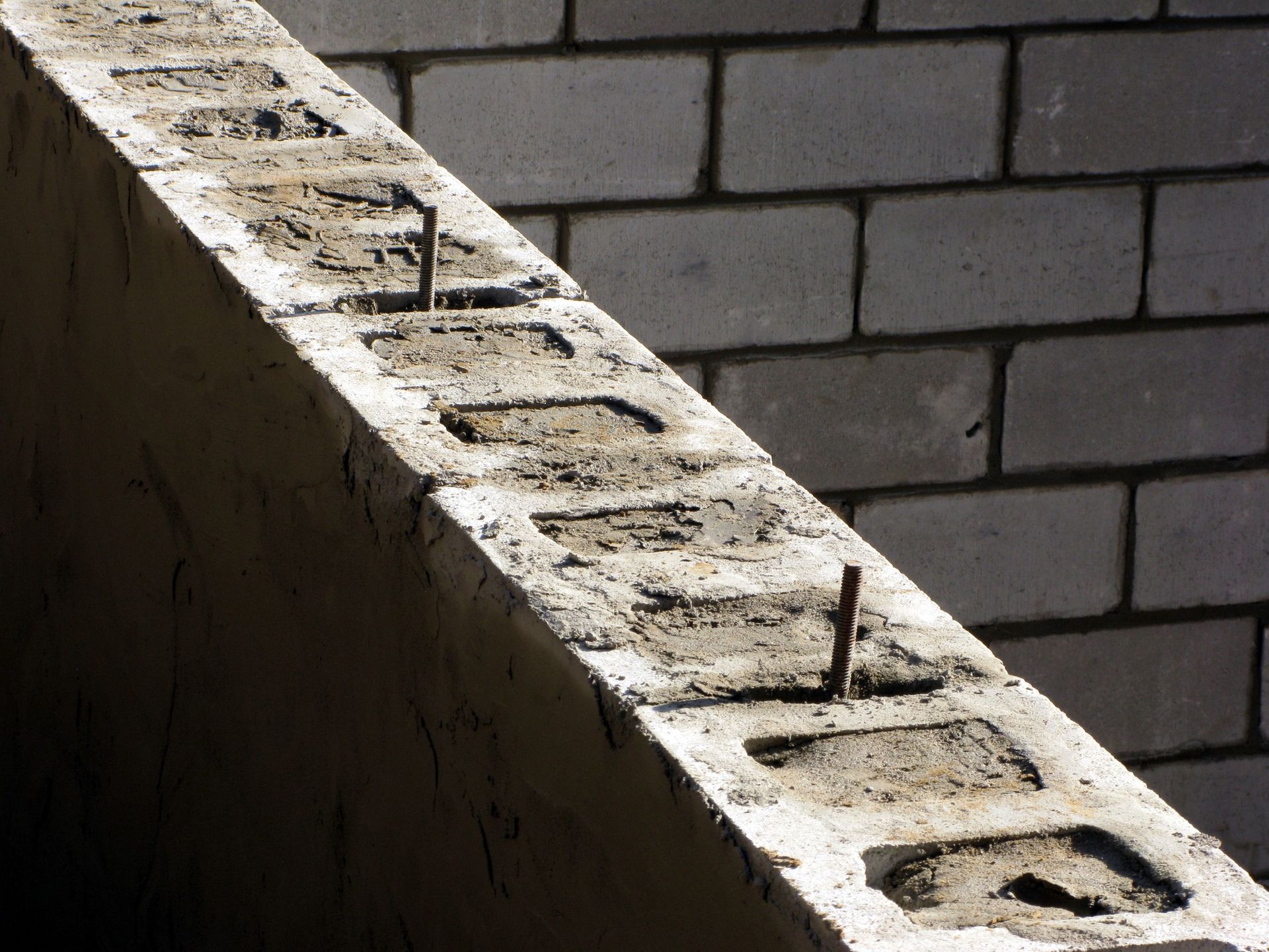 A brick wall with a concrete block in the middle