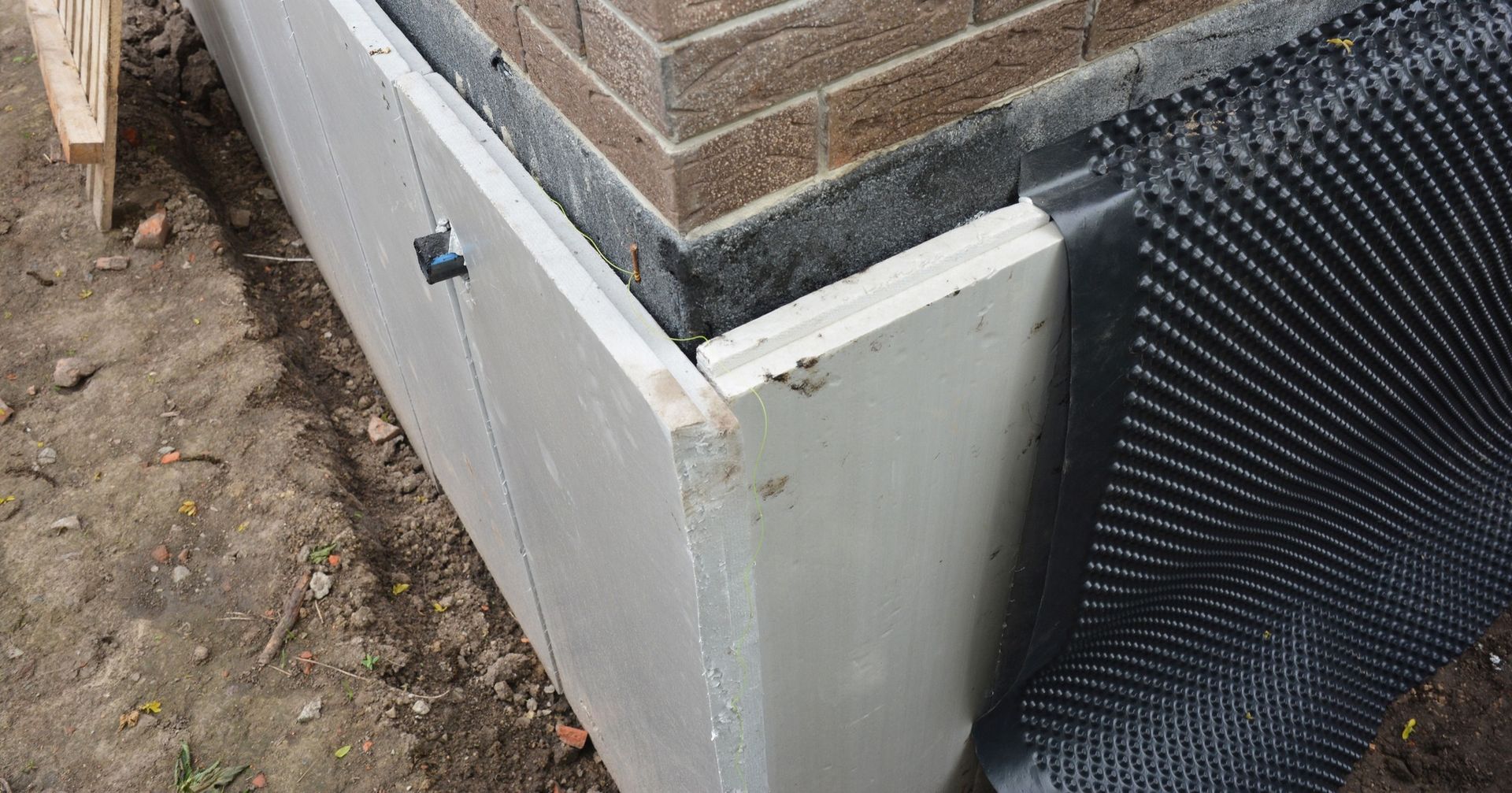 A brick wall with a drainage mat on it.