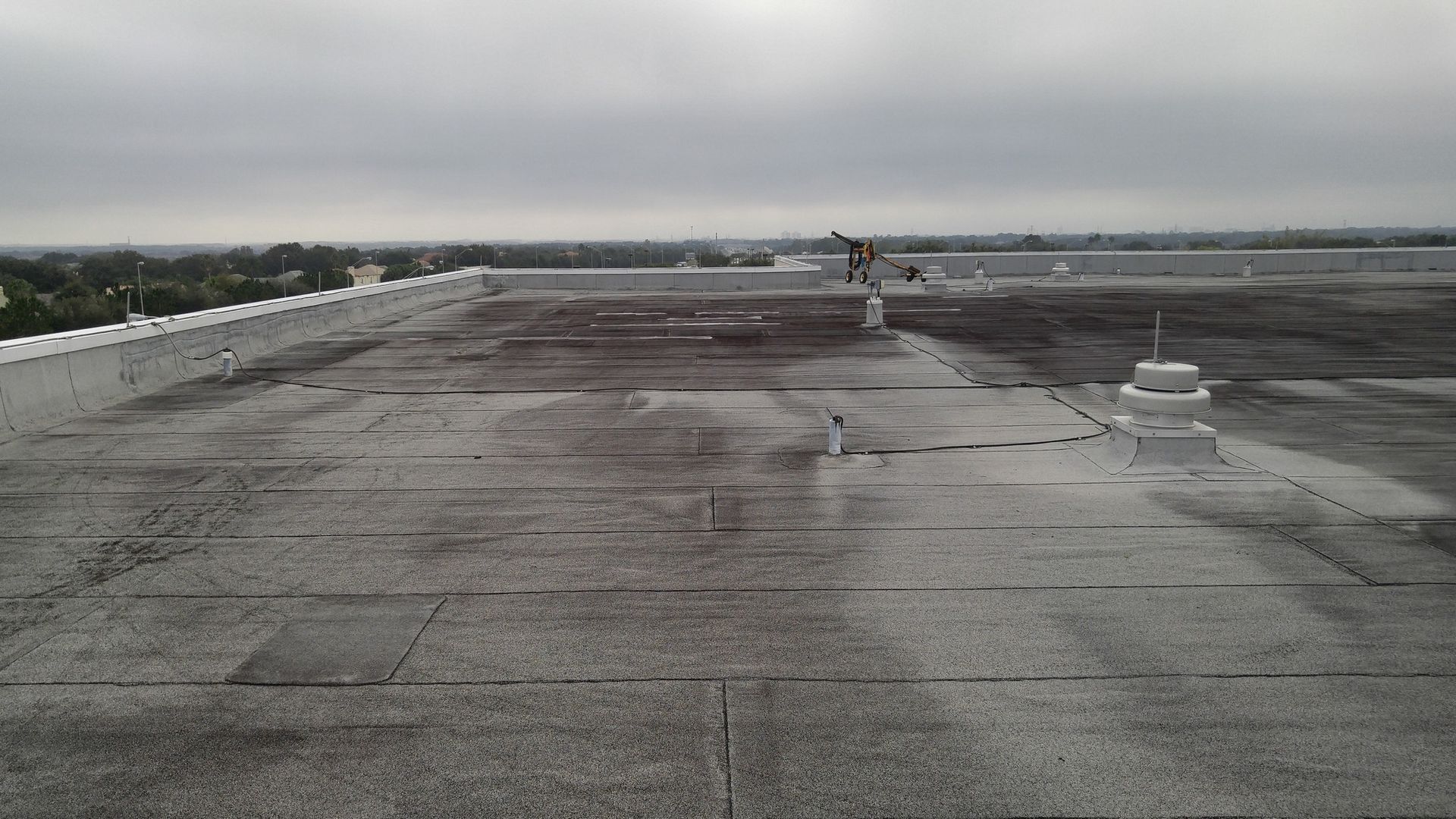 A black and white photo of a roof with a cloudy sky in the background.
