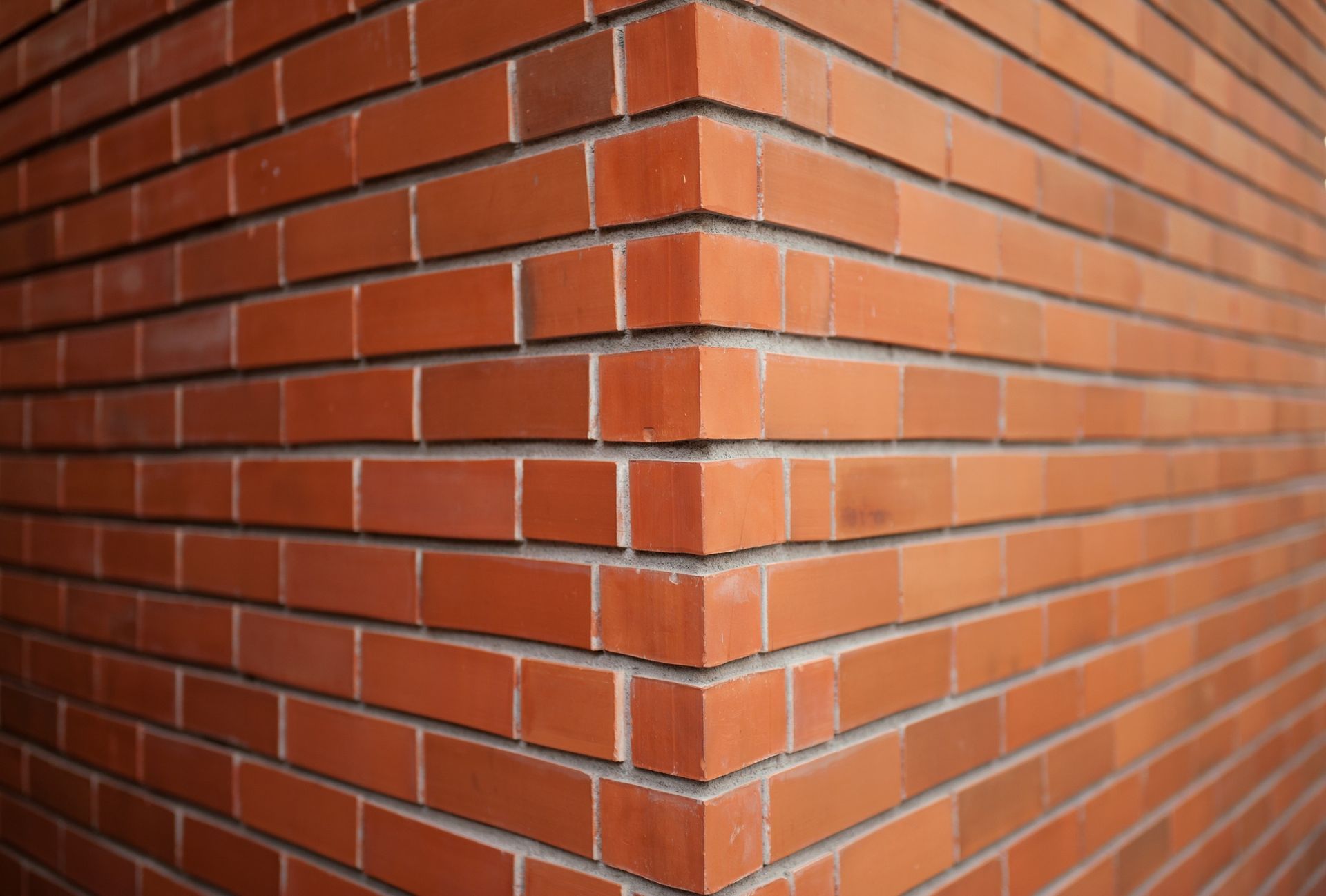 A close up of a red brick wall with a corner.