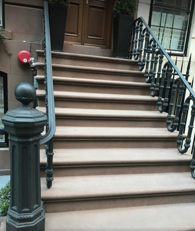 A set of stairs leading up to a building with a black railing