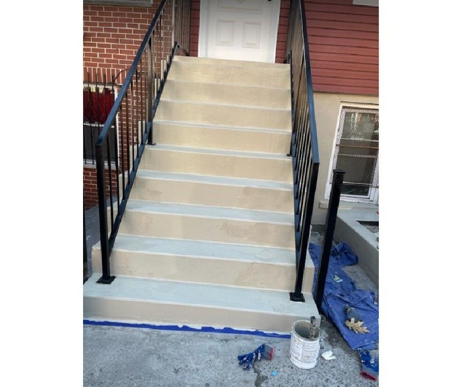 A set of stairs being painted in front of a brick building