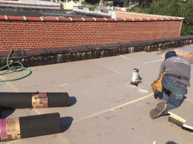 A man is working on the roof of a building
