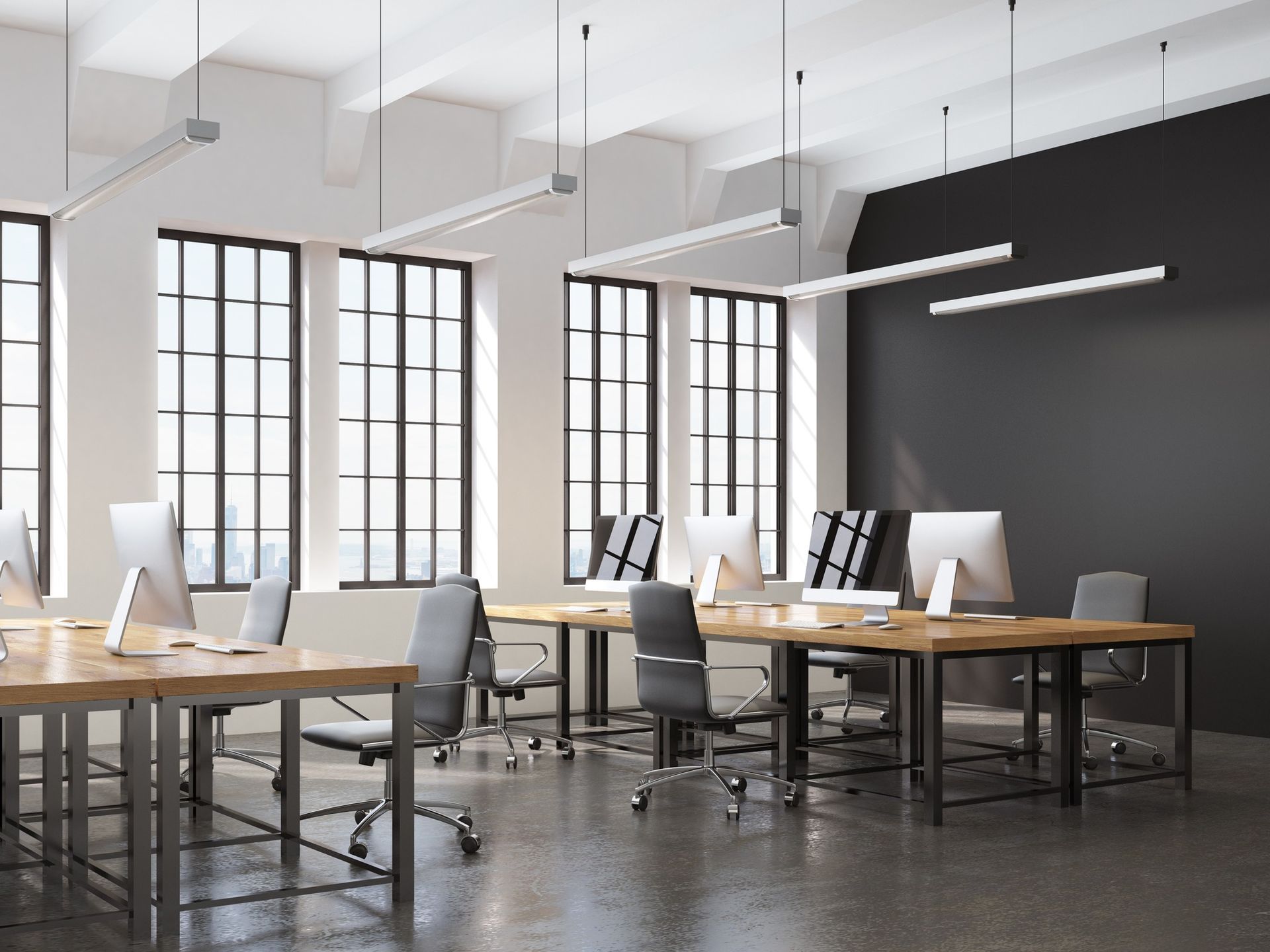 An empty office with tables and chairs and computers.