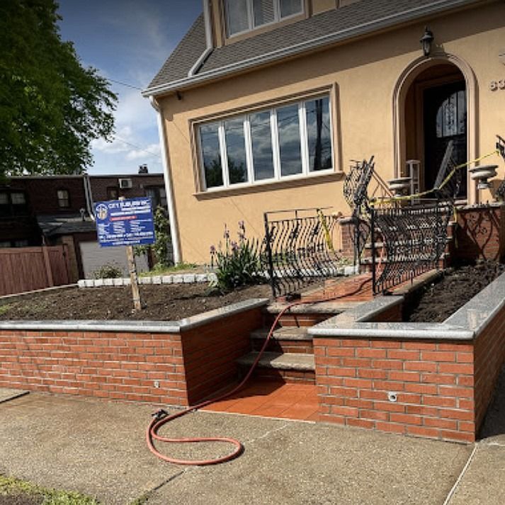 A hose is attached to a brick wall in front of a house.
