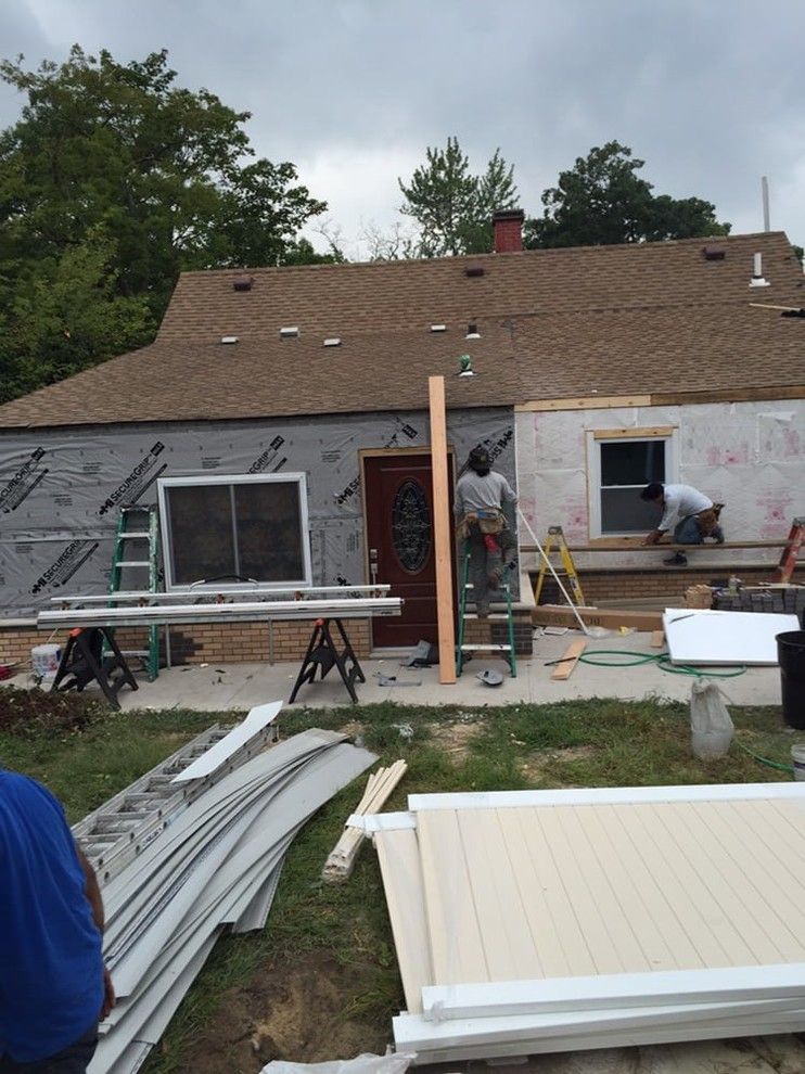 A group of people are working on a house