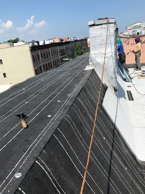 A man is working on a roof with a rope attached to it