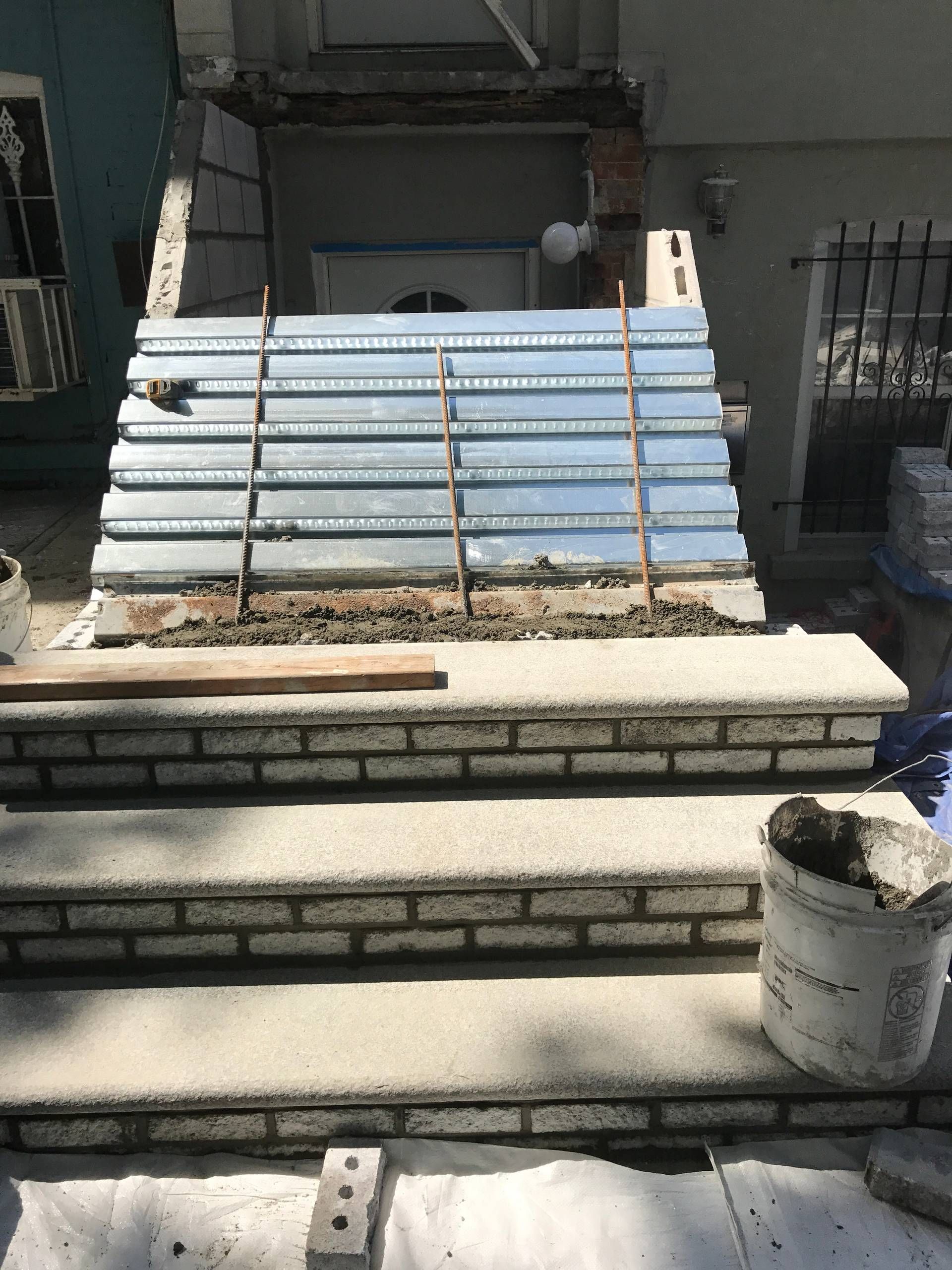 A brick staircase is being built in front of a building.