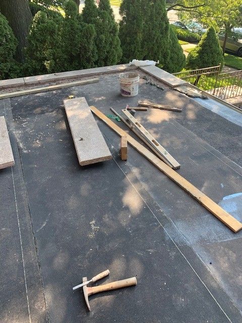 A hammer and a ruler are laying on a roof.