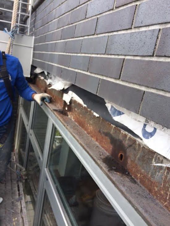 A man is working on a brick wall with a spatula.