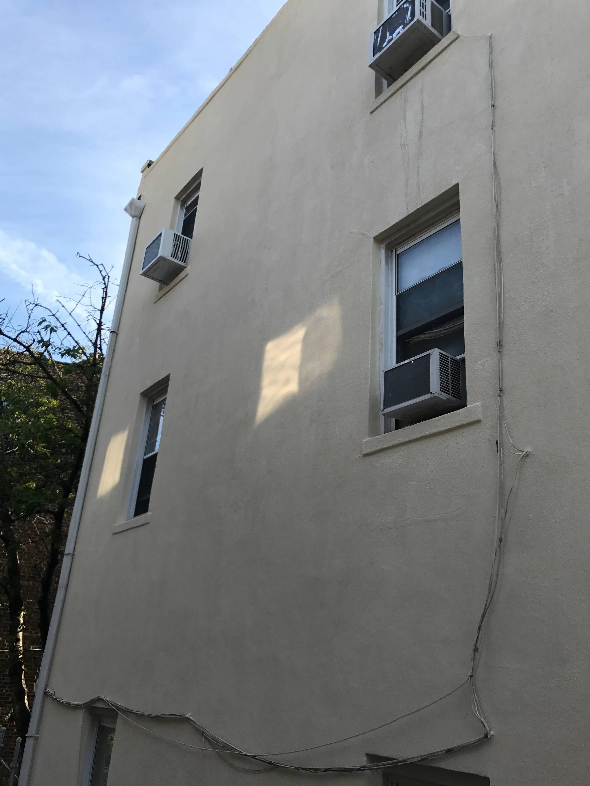 A building with a lot of windows and air conditioners