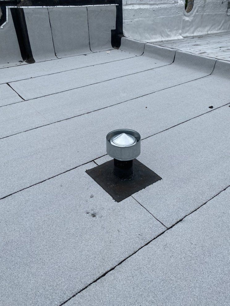 A roof with a vent on it and a light on top of it.