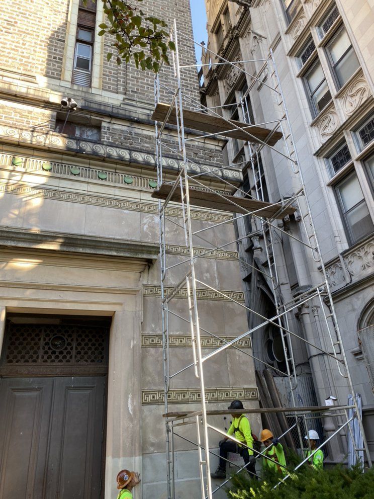 A group of construction workers are working on a building with scaffolding.