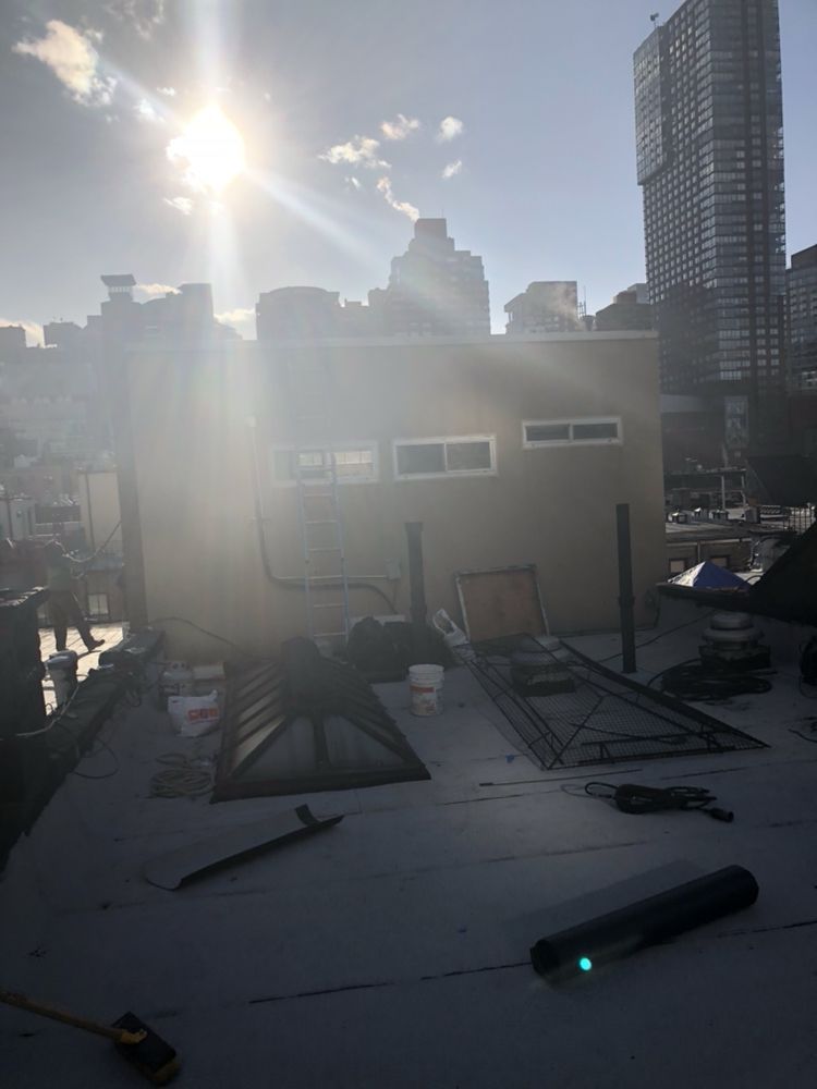 The sun is shining through the clouds on the roof of a building.